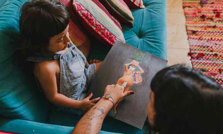 Yanaki Herrera aponta pintura com o dedo para o filho ver