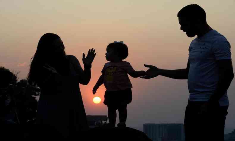 Pai, me e filha sob o sol quente 