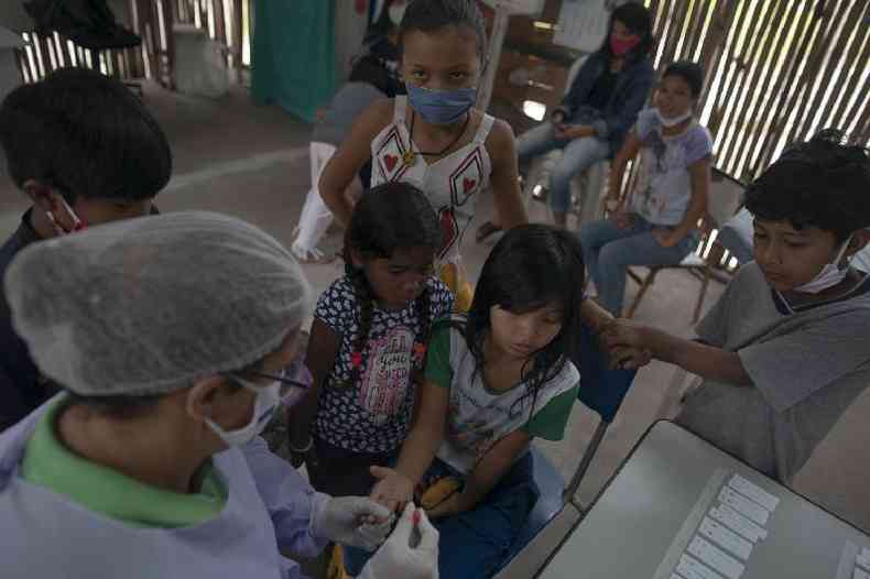 Profissional de saúde faz testes de covid-19 em crianças em um acampamento guarani em Maricá, no Rio de Janeiro, em 2 de julho de 2020