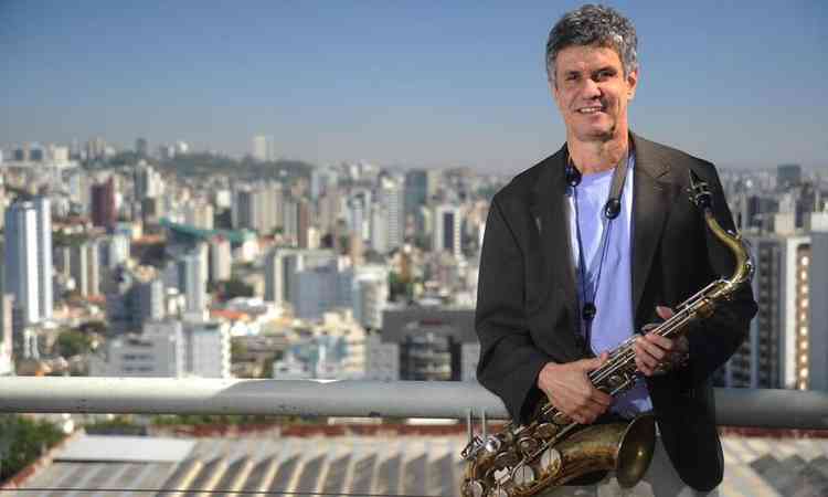 Chico Amaral sorri, segurando o saxofone. Ao fundo, v-se Belo Horizonte