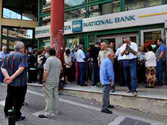 Com bancos fechados e saques limitados, populao fez filas nas portas das agncias no incio do dia na tentativa de obter o dinheiro(foto: AFP PHOTO / SAKIS MITROLIDIS )