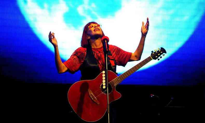 Rita Lee canta no palco do Arena Hall, tendo imensa lua atrs de si