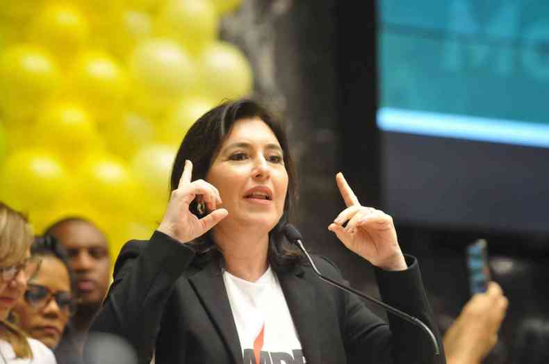 Simone Tebet fala e gesticula durante a conveno do MDB na Assembleia legislativa; atrs dela, bales amarelos, cor do partido