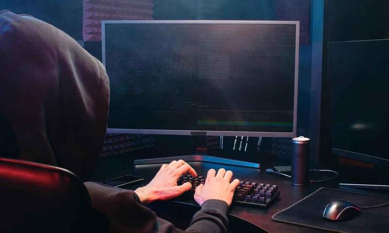 (foto: Dmitry shibanov Bratsk vk.com/reklamist1) Homem vestindo capuz digita em computador