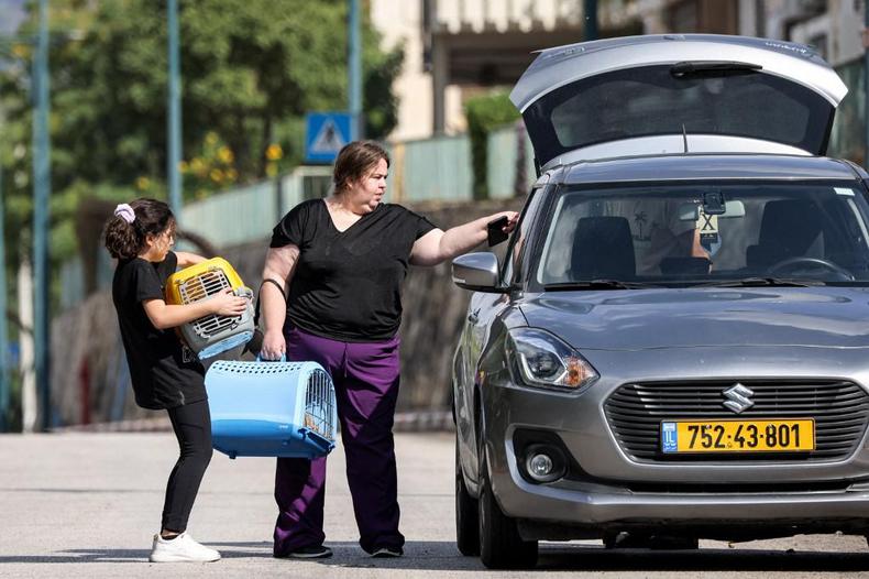 Mulheres com seus pets se preparam para deixar Kyriat Shmona, no norte de Israel