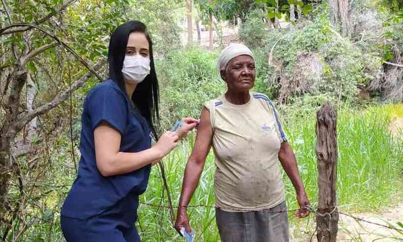 Agente de sade vacina moradora da comunidade de gua Clara, na zona rural de Botumirim(foto: Secretaria de Sade de Botumirim/Divulgao)