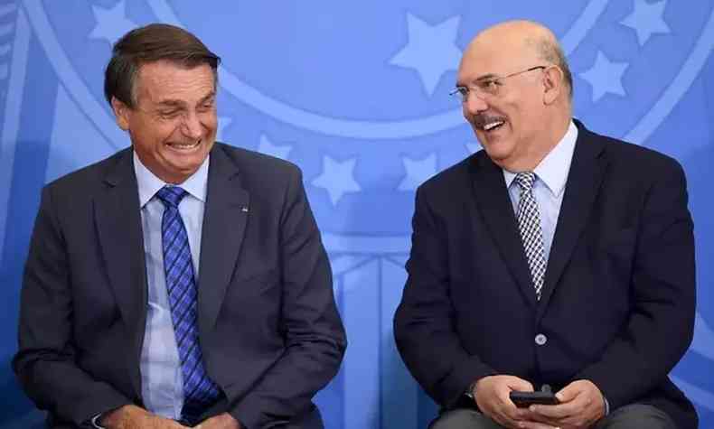 Bolsonaro e Milton Ribeiro sentados lado a lado e sorrindo 