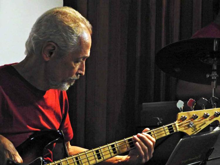 Fernando Leporace est de lado, tocando baixo