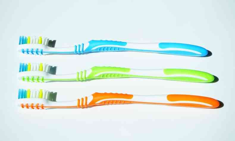 trs escovas de dente coloridas