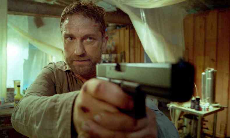 Com expresso tensa, ator Gerard Butler aponta arma em cena de 'Caa implacvel'