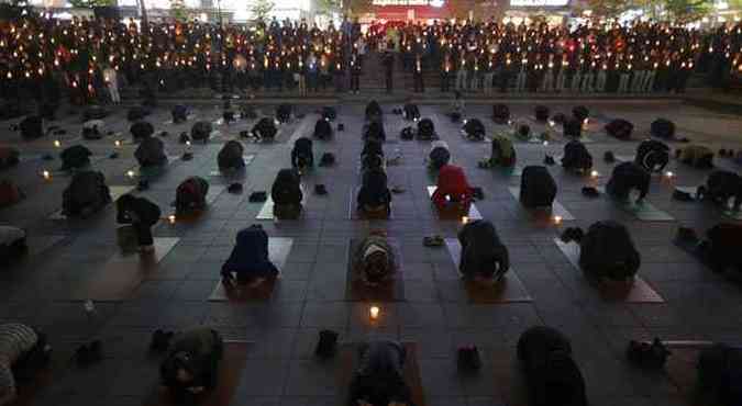 Famlias fazem orao coletiva,  luz de velas, enquanto esperam por informaes sobre os desaparecidos em naufrgio(foto: Kim Hong-Ji/Reuters)