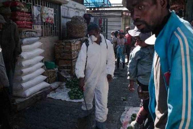 Funcionário dos órgãos de saúde desinfeta corredores de mercado em Antananarivo (foto: RIJASOLO/AFP) Funcionário dos órgãos de saúde desinfeta corredores de mercado em Antananarivo (foto: RIJASOLO/AFP)