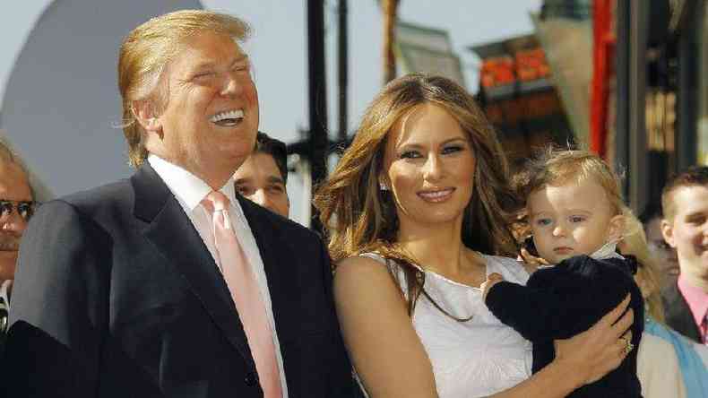 Trump ao lado de Melania, que segura beb no colo; o casal sorri