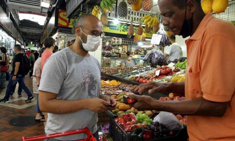 Homem recebendo frutas do vendedor