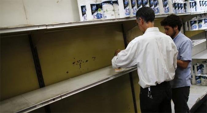Funcion�rios de supermercado em Caracas trabalham nas prateleiras de papel higi�nico, parcialmente vazias: descontentamento com falta de produtos e infla��o de 12,5% no ano(foto: JORGE SILVA/Reuters)