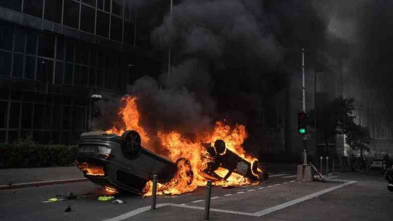 Carro capotado e incendiado durante protestos na Frana