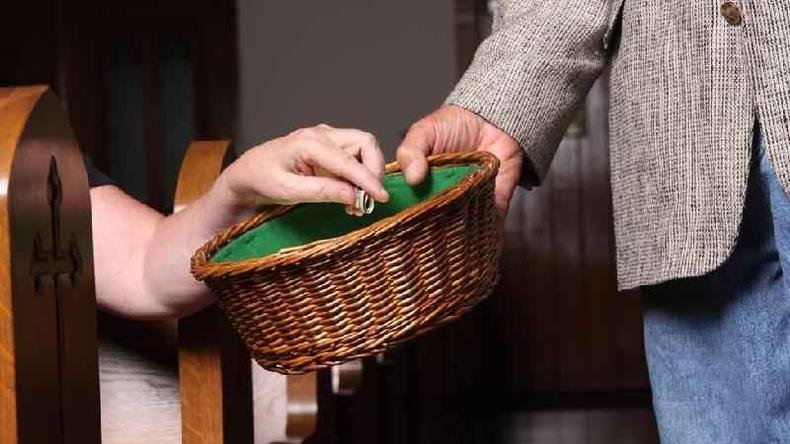 Pessoa recolhendo doa��es com cesto na igreja