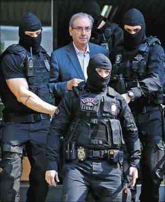 Escoltado por agentes armados e encapuzados, Cunha chega ao IML e cumprimenta jornalistas(foto: Heuler Andrey/AFP)