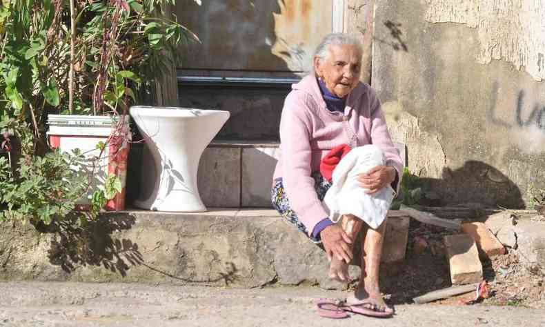 Jlia Guimares, 82 anos, sentada na porta de casa