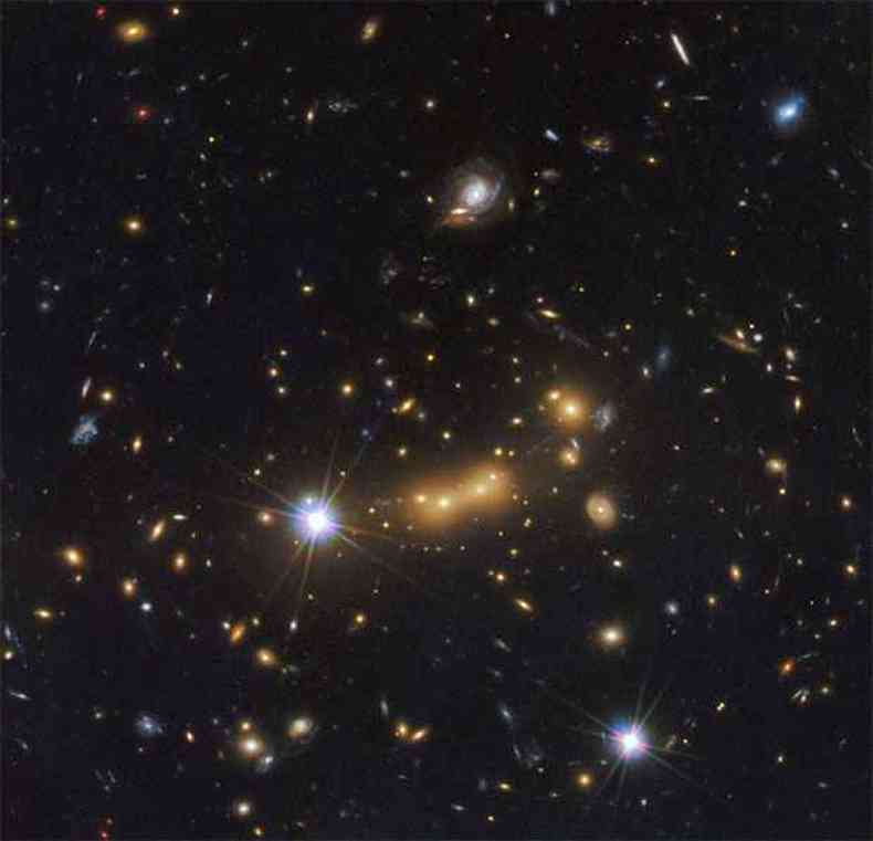 Imagem captada pelo telescpio Espacial Hubble da galxia MACS J0647.7 7015. Os astrnomos usaram a poderosa gravidade do cluster para ampliar a luz de uma galxia muito mais distante chamada MACS0647-JD(foto: AFP PHOTO /ESA/HUBBLE)