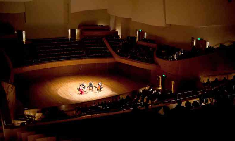Iluminado por holofotes, quarteto formado por integrantes da Filarmônica mineira, se apresenta no palco da Sala Minas Gerais