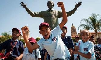 Crian�as posam em frente � est�tua de Mandela na Union Buildings, resid�ncia oficial do governo na �frica do Sul, em Pret�ria(foto: STEFAN HEUNIS / AFP)
