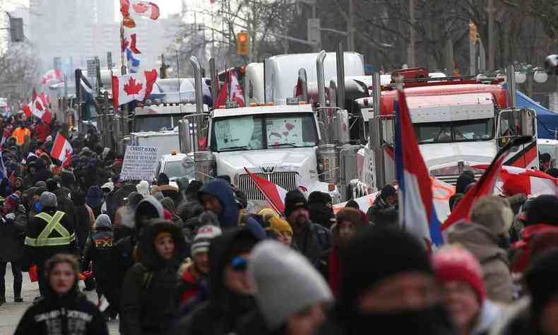 Manifestantes e apoiadores passam por caminhes estacionados enquanto os manifestantes continuam protestando contra os mandatos do Covid-19 em 12 de fevereiro de 2022 em Ottawa, Canad