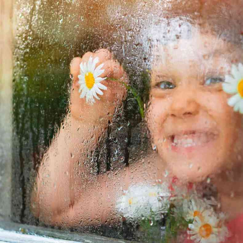 Imagem de criana brincando na janela durante a chuva(foto: Freepik)