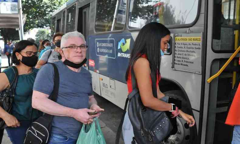 Imagem mostra Edilson entrando no ônibus. Ele é um homem de cabelo branco e óculos. Na foto, ele segura uma sacola de plástico e o celular, enquanto aguarda na fila para entrar no ônibus.
