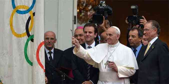 Francisco abenoa a bandeiras olmpica durante encontro com Cabral e Paes no Rio de Janeiro(foto: AFP PHOTO / GABRIEL BOUYS )