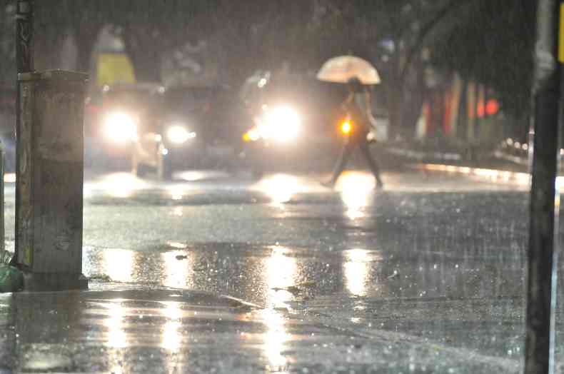 carro passa em avenida durante chuva 