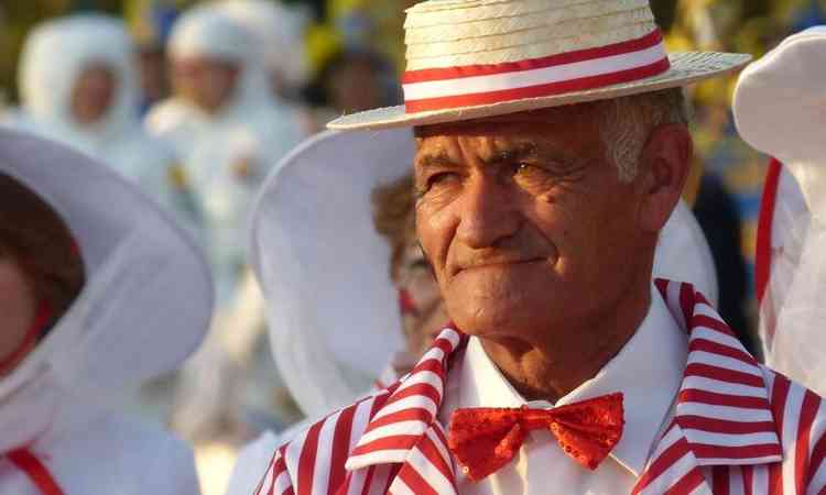 senhor de fantasiada de terno vermelho e branco com chapu para o carnaval