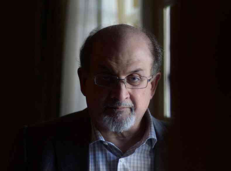 Escritor Salman Rushdie posa para foto. Ele  cara, usa barba e culos
