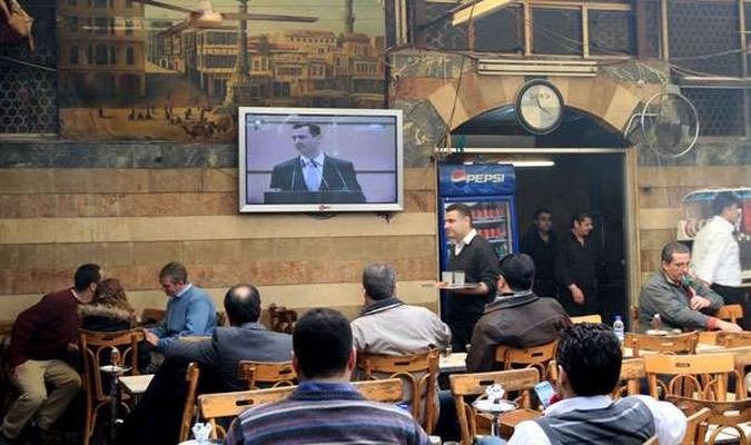 Em um bar na capital Damasco, populares assistem ao pronunciamento do presidente sírio (foto: AFP PHOTO/LOUAI BESHARA ) Em um bar na capital Damasco, populares assistem ao pronunciamento do presidente sírio (foto: AFP PHOTO/LOUAI BESHARA )
