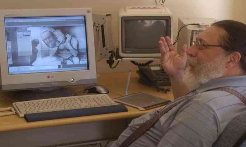 O perito est em frente a um computador com fotos do jornalista Vladmir Herzog
