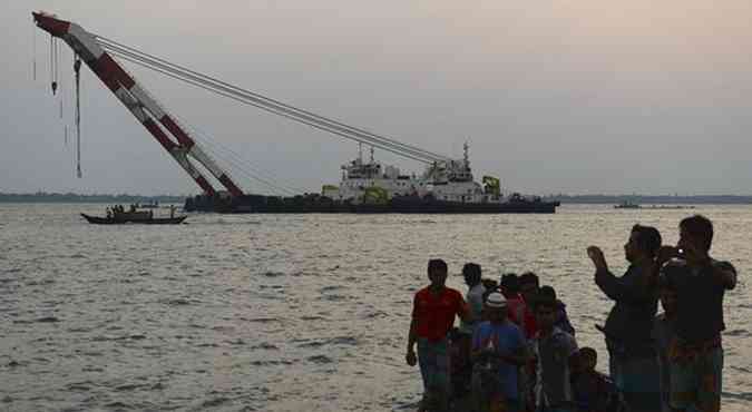 Pessoas assistem a movimentação de navio que faz resgate balsa que afundou e deixou centenas de desaparecidos(foto: REUTERS)