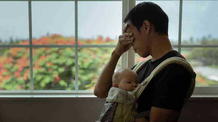Homem chora enquanto segura beb