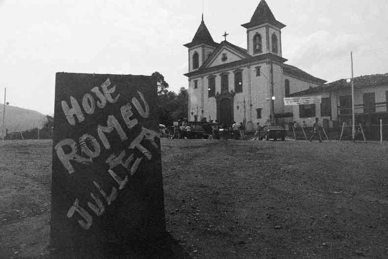 foto p&b mostra placa em que se l 'hoje, Romeu e Julieta', em frente a igreja de Morro Vermelho