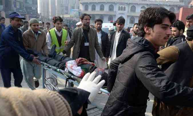 Paquistaneses carregam um estudante em uma maca at um hospital de Peshawar(foto: A Majeed/AFP)
