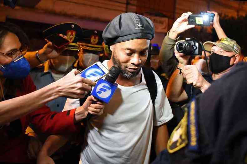 Ronaldinho Gacho chega a hotel na capital paraguaia aps pagar fiana milionria, cercado por imprensa e policiais protegidos com mscaras(foto: Norberto DUARTE/AFP)