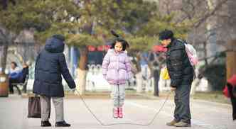 Menina pula corda com os pais em praa de Pequim. Agora, casais em que, pelo menos um dos pais no tem irmos, podero ter dois filhos(foto: WANG ZHAO/AFP)