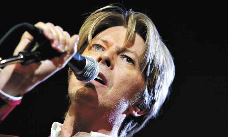 David Bowie canta, com a franja caindo na testa