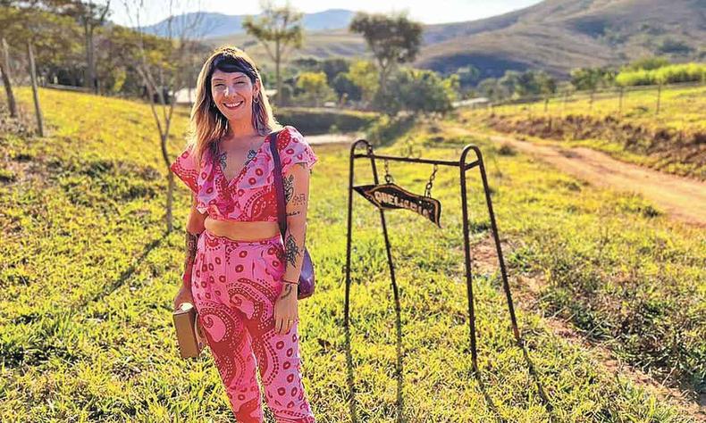 Lorena K. Martins escreveu livro sobre o modo de vida das 800 famílias produtoras de queijo na Serra da Canastra (foto: Thiago Alves/Divulgação) Lorena K. Martins de pé junto a placa que indica direção para queijaria da serra da canastra