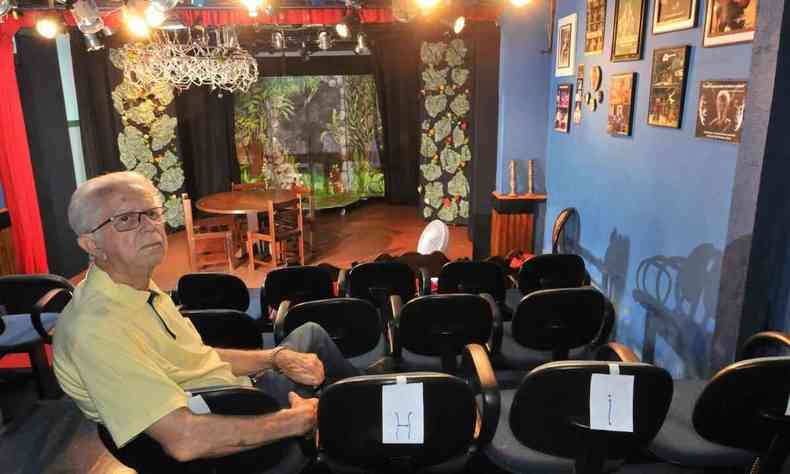 O ator Raimundo Farinelli est sentado no teatro que construiu em sua casa, em BH. Nas paredes h cartazes de peas e ao fundo cadeiras como as de plateia de teatro