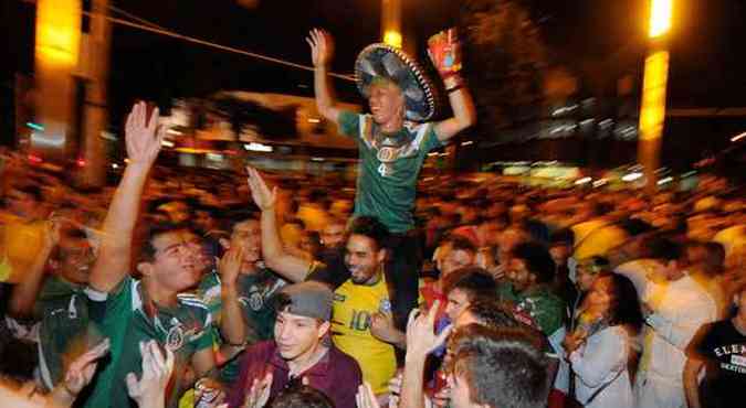 Japons usou sombrero e torceu pelo Mxico, na Savassi, sobre os ombros de um brasileiro(foto: Tlio Santos/EM/D.A Press )