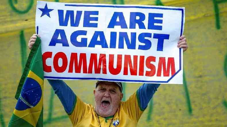 Manifestante segura cartaz com frase em ingls 'ns somos contra o comunismo' em So Jos dos Campos, interior de SP