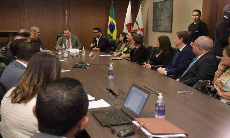 Pessoas sentadas em volta de uma mesa