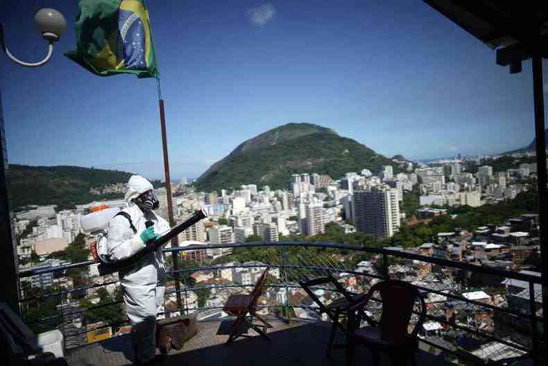 Voluntrio faz limpeza em rea de favela na capital fluminense. Estado  o segundo no ranking de mortes por COVID-19 no Brasil (foto: Mauro Pimentel/AFP %u2013 20/4/20)