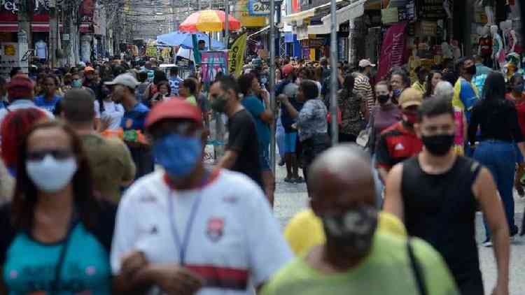 Pessoas em rua comercial movimentada usando mscaras de proteo contra a covid