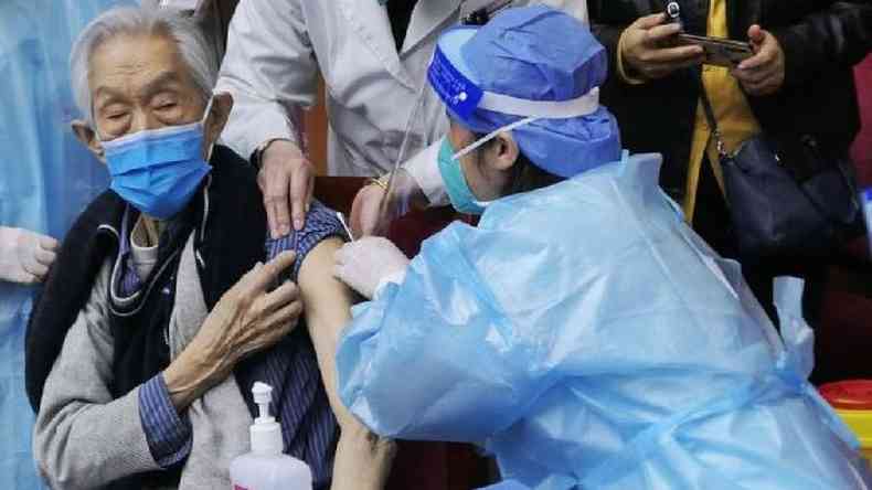 Homem sendo vacinado em Pequim